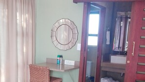 A room with a desk, a chair, a sofa, and a bed.