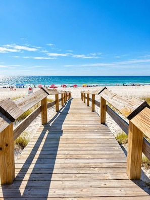 Scenic wooden beach boardwalk, direct path toward the shoreline, sugar-white sand, turquoise Gulf waters, peaceful coastal scenery
