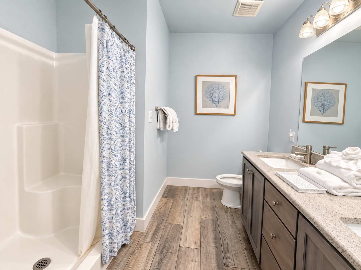 Une salle de bain équipée d’une douche, de toilettes, d’un lavabo et d’un meuble-lavabo.