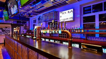 A bar with multiple taps, a counter, and a sign that reads "TEQUILA CHEAPEN".