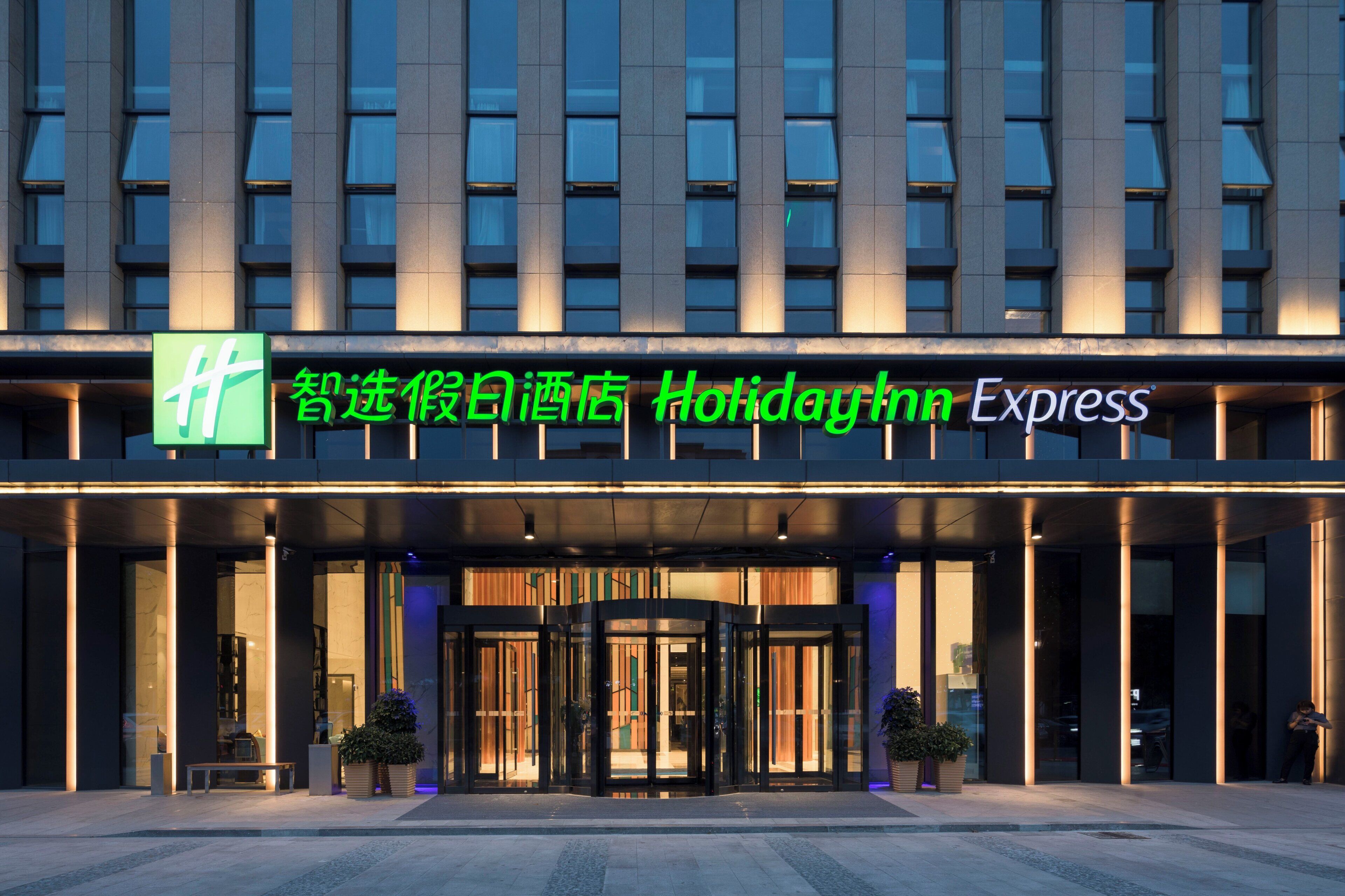 A hotel entrance with a glass door and a sign above it.