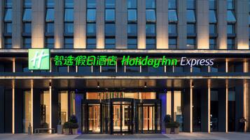 A hotel entrance with a glass door and a sign above it.