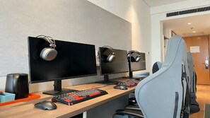 A modern office setup with three monitors, a keyboard, a mouse, and headphones on each desk. - Holiday Inn Express Qingdao Chengyang Central by IHG (Qingdao)