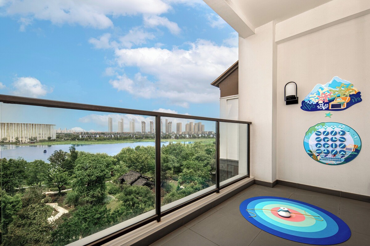 Varanda com vista para a paisagem urbana e um lago.