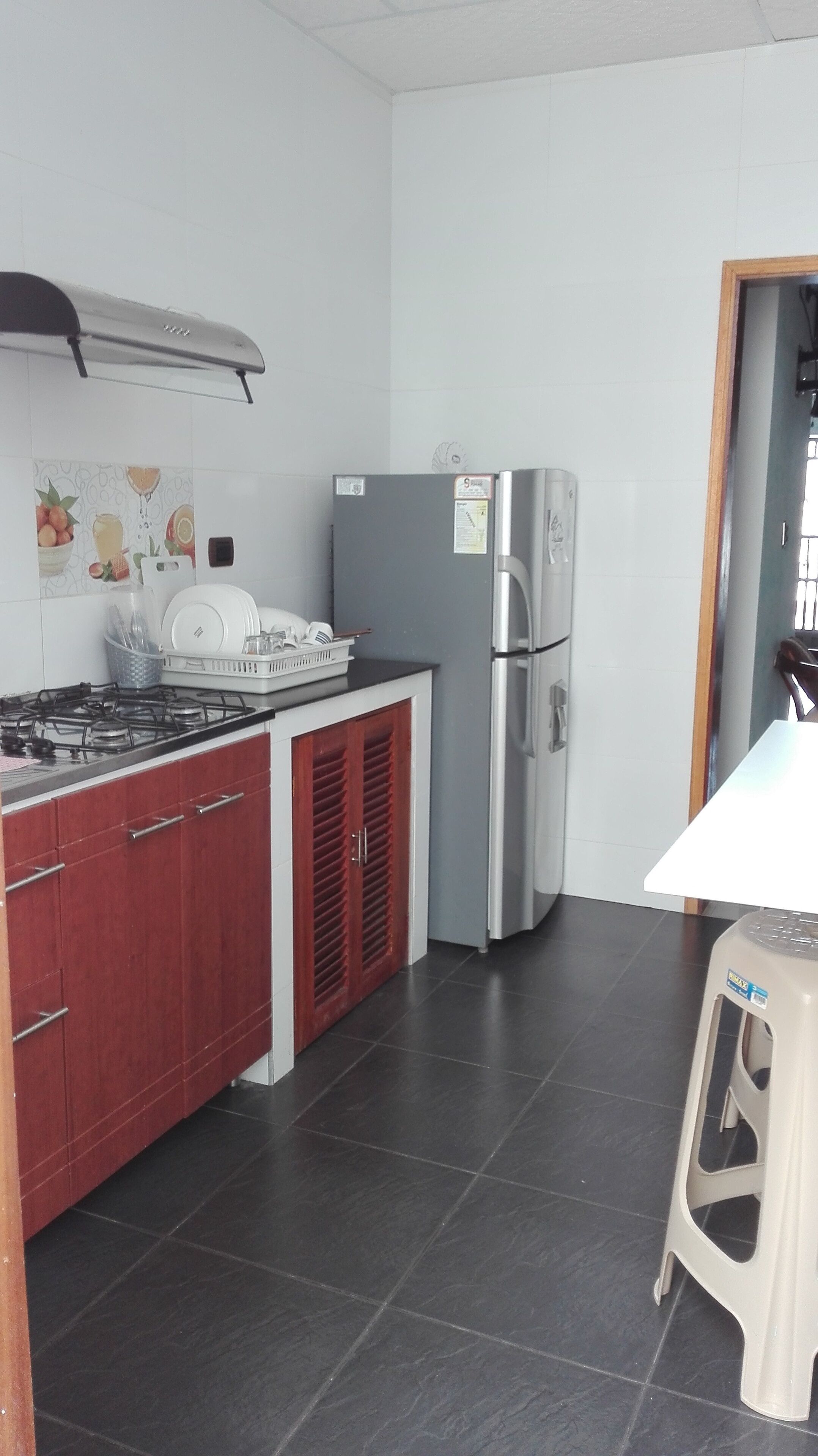 Frigorífico, placa de cocina, utensilios de cocina y mesa de comedor