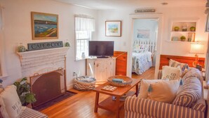 Una sala de estar acogedora con chimenea, televisor y un espacio de descanso confortable.