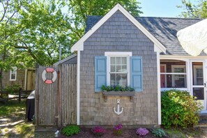Stylish single-story home with a charming porch, white-framed window, and a decorative anchor.