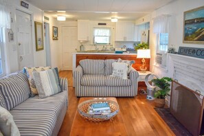Relax in this inviting living room with a fireplace, sofa, and armchair, perfect for unwinding.