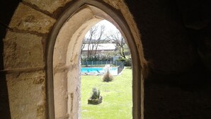 A stone archway leading to a backyard with a swimming pool, a lawn, and a small garden. - Private pool and secluded garden.  Sleeps 4 adults  maximum + 4 children. (Édon)