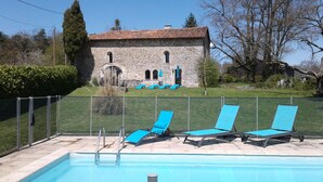 A swimming pool with blue lounge chairs and a stone building in the background. - Private pool and secluded garden.  Sleeps 4 adults  maximum + 4 children. (Édon)