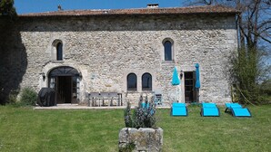 A stone building with a covered entrance, outdoor seating, and blue lounge chairs. - Private pool and secluded garden.  Sleeps 4 adults  maximum + 4 children. (Édon)