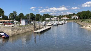 A marina with boats docked along a calm waterway, surrounded by residential buildings and greenery.