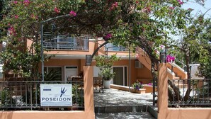 Un bâtiment à deux étages doté d’un balcon, d’une enseigne et d’un petit espace extérieur aménagé avec des sièges.