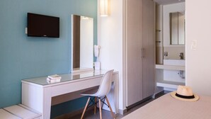 Une chambre d’hôtel moderne équipée d’un bureau, d’une chaise et d’une armoire.