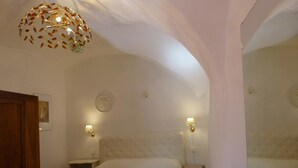 A bedroom with a bed, two bedside tables, a wall-mounted lamp, and a ceiling light fixture. - Agriturismo Un Posto al Sole (Diano San Pietro)