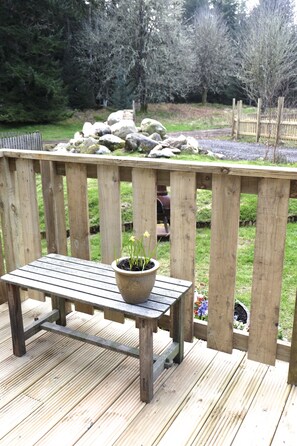 A wooden deck with a bench and a potted plant. - Apple Pip (Fort Augustus)