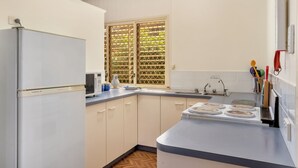 Una cocina compacta con refrigerador, microondas y estufa.
