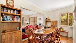 Un comedor con una mesa de madera, sillas y una estantería.