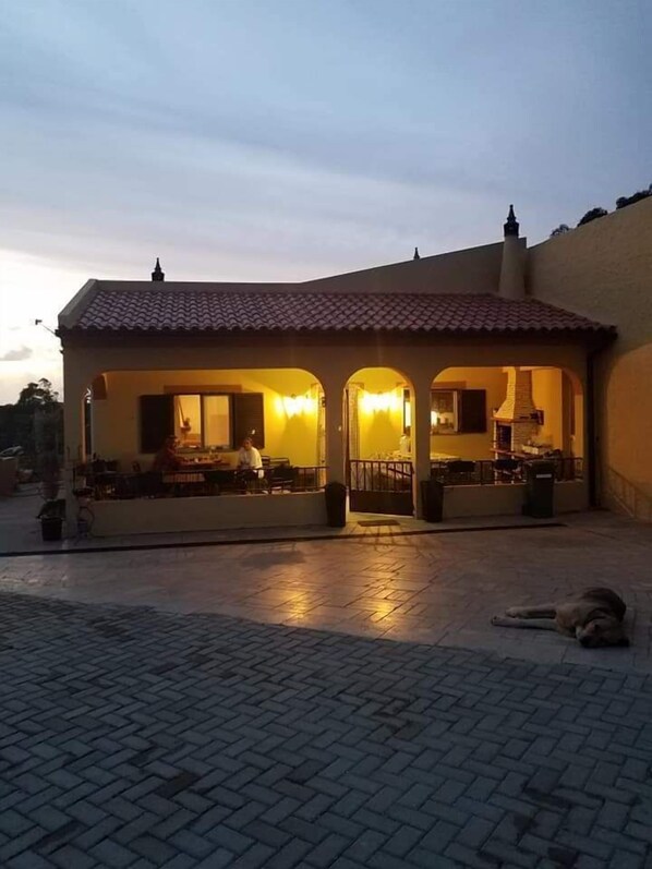 Vista frontal de la propiedad por la tarde o noche