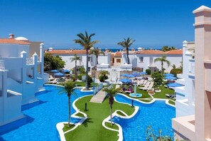 Ett semesterhotell med en central pool, avkopplande områden och utsikt över havet.