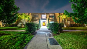 A building with a central entrance, surrounded by well-maintained lawns and trees. - Stay Avenida Westshore (Tampa)