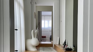 Una escalera conduce a una habitación con una silla blanca y un pequeño árbol de Navidad.