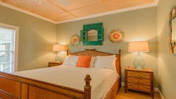 A bedroom with a wooden bed, two nightstands, and a ceiling fan.
