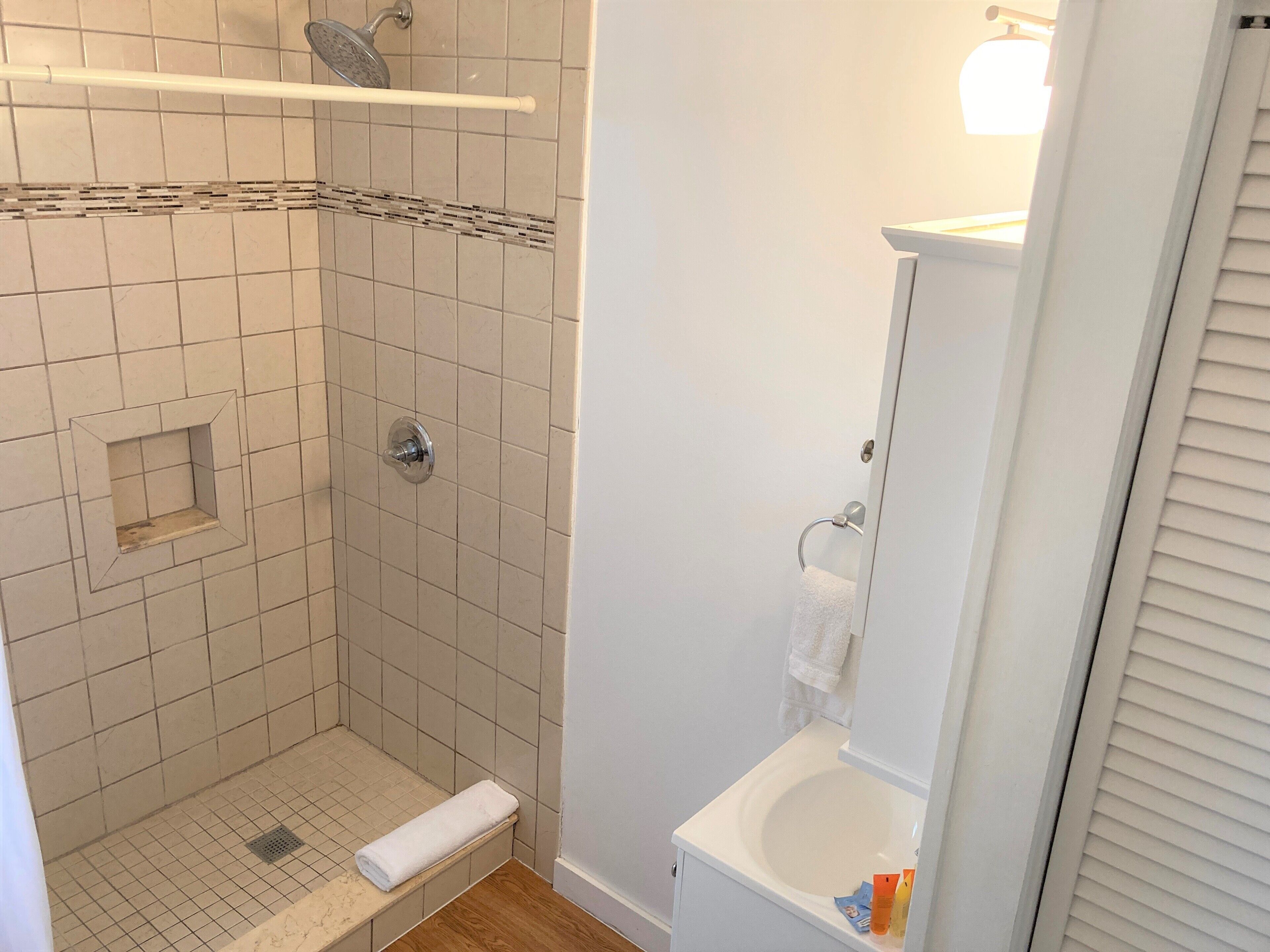 A bathroom with a shower, toilet, and sink.
