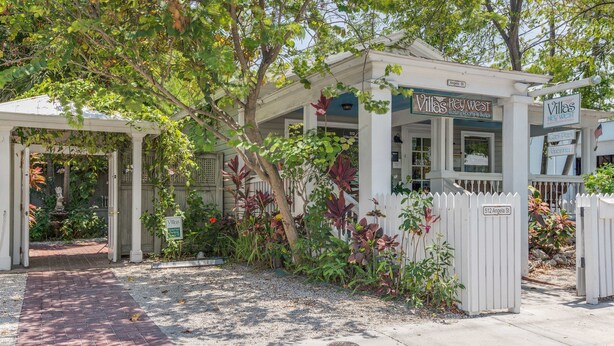 A gated entrance to Villas Key West with a brick pathway leading to the gate. - Key West Villas (Key West)