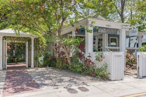 A gated entrance to Villas Key West with a brick pathway leading to the gate.