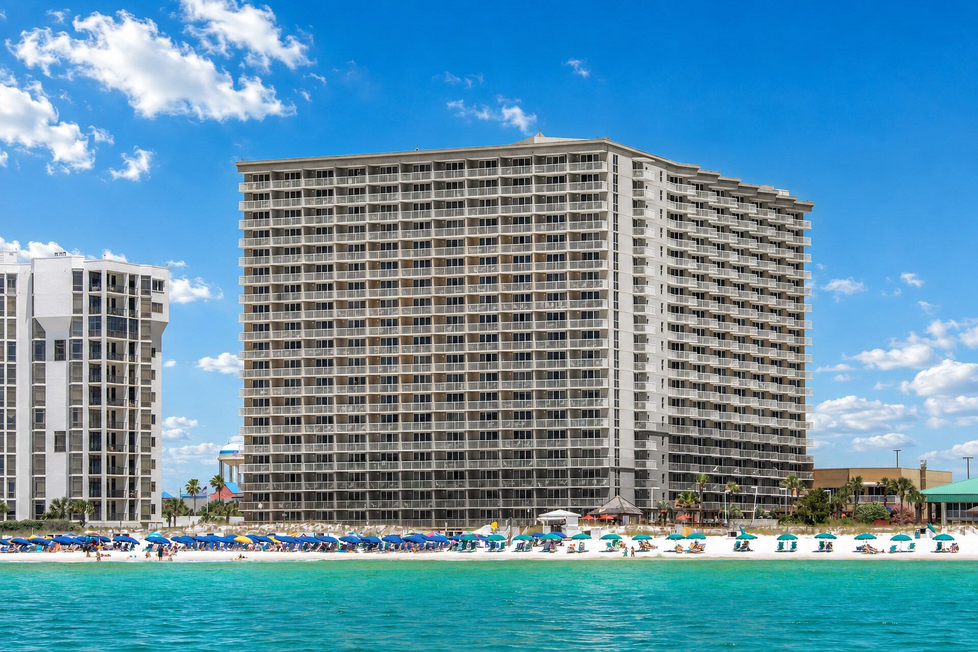 Un hôtel de grande hauteur doté de nombreux balcons, situé en bord de mer et offrant une vue sur l’océan.