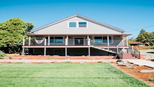 A two-story house with a covered porch and a staircase leading to the upper floor.