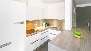 A modern kitchen with white cabinets, a wooden countertop, and a built-in stove. - Lagoon! Pretty villa at 2 steps from the lagoon of Saline les bains (La Saline-Les-Bains)