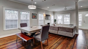 A spacious living area with a dining table, a sofa, and a fireplace.