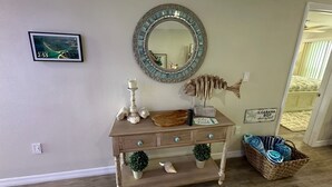 A room with a wooden vanity, a decorative mirror, a framed picture, and a sign reading "Oh, CABANA BOY". - Direct Gulf View, Beach Condo on Manasota Key, FL (Englewood)