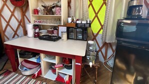 A compact kitchen with a coffee bar, shelves with kitchenware, and a microwave. - Fantastic and Fun “O Canada" Yurt, sleeps 4 (Rigby)