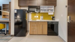 A modern kitchen with a refrigerator, microwave, sink, and dishwasher.