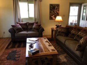 A living room with two sofas, a coffee table, and patterned rugs.