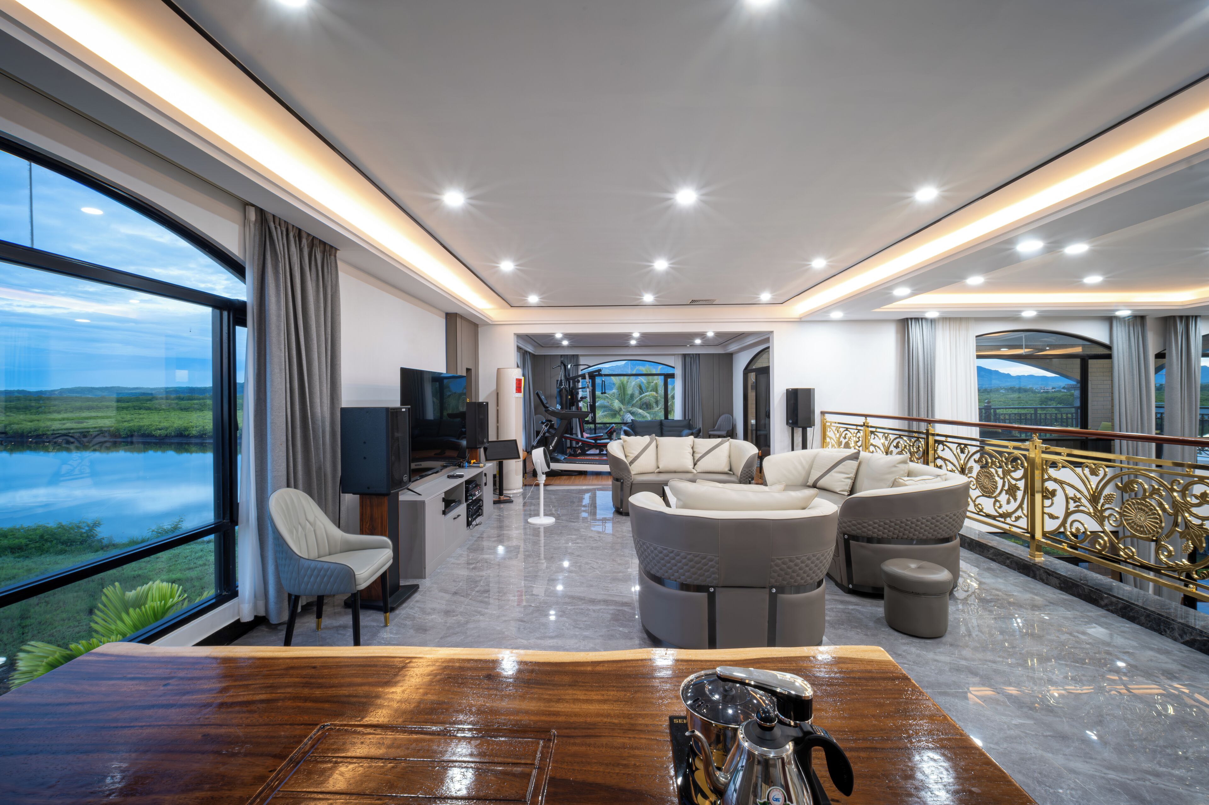 A spacious living area with a large window, a wooden table, and a seating arrangement.