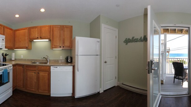 A spacious kitchen with wooden cabinets, a microwave, a stove, and a dishwasher. - Atlantic Ocean Suites - Sand Castle Suite 7 (Old Orchard Beach)