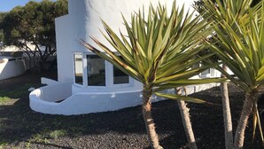 Un edificio moderno blanco con un ventanal circular y un pequeño balcón.