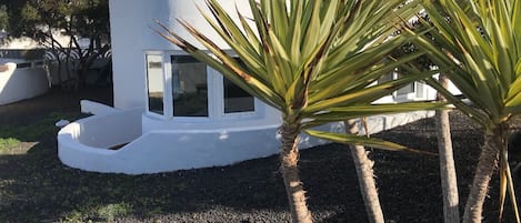 Un edificio moderno e bianco con una finestra circolare e un piccolo balcone.
