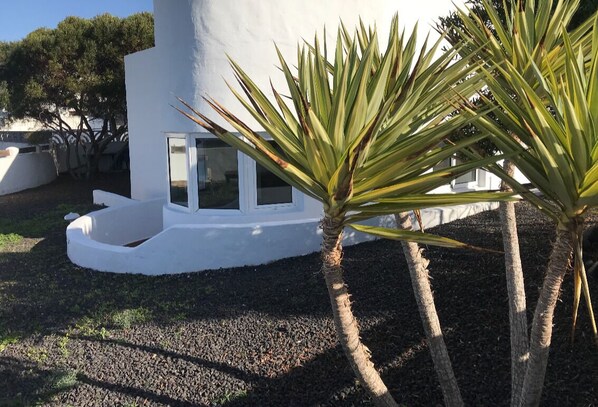 Um edifício moderno branco com uma janela circular e uma pequena varanda.