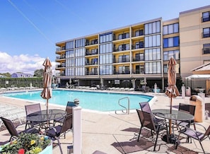 A hotel with a swimming pool, outdoor seating, and a multi-story building with balconies. - 2b/2b Beachfront Oceanview with POOL (Brigantine)
