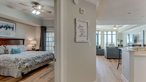 Een moderne slaapkamer met een groot bed, een plafondventilator en een nachtkastje met een lamp.