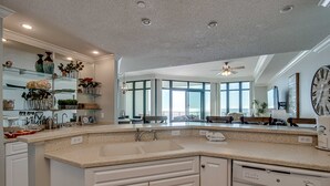 Een moderne keuken met een groot eiland, ingebouwde apparatuur en een grote spiegel.