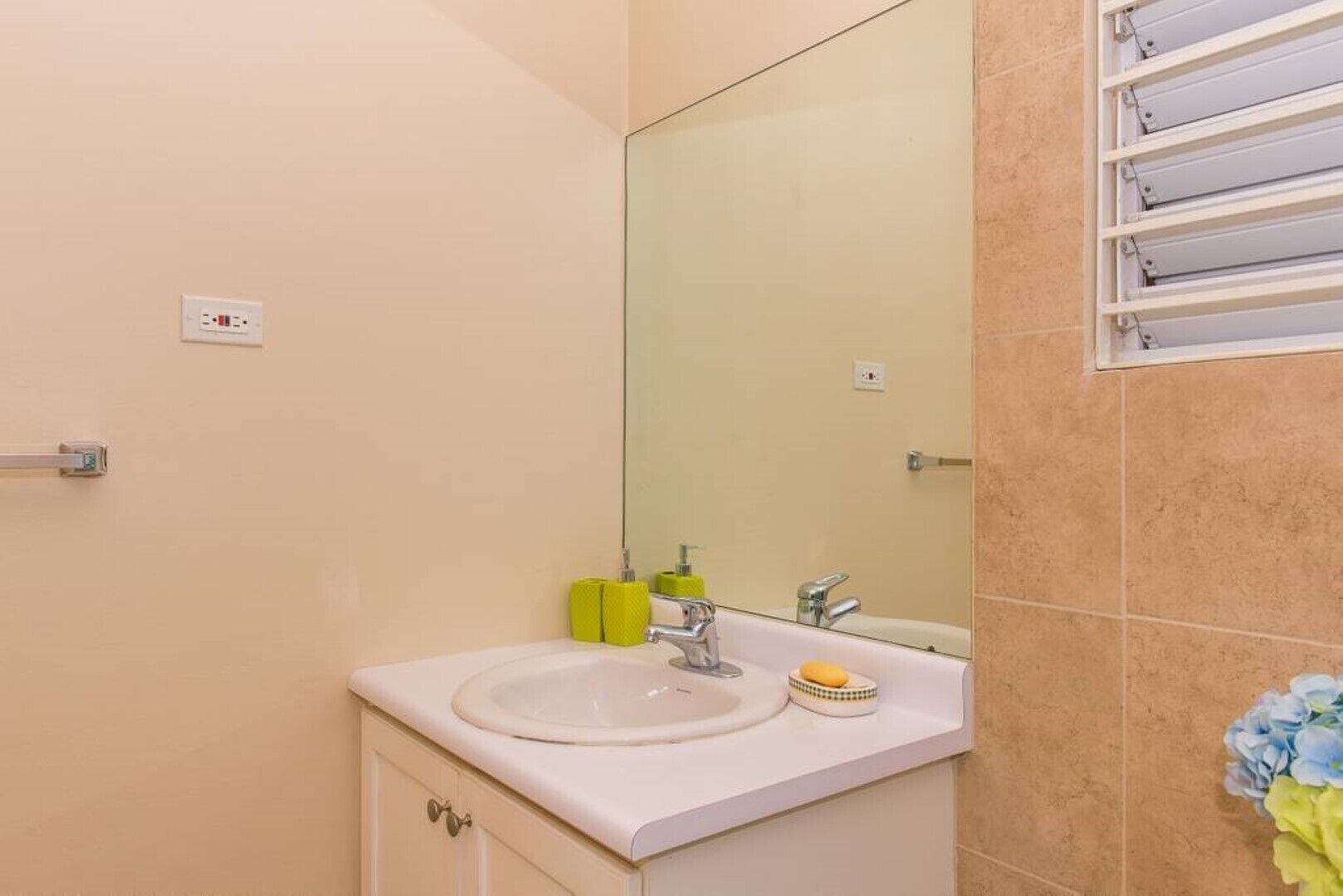 A bathroom with a sink, mirror, and towel rack.