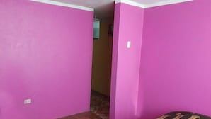 A room with pink walls and a patterned bedspread. - Third floor apartment (Ayacucho)