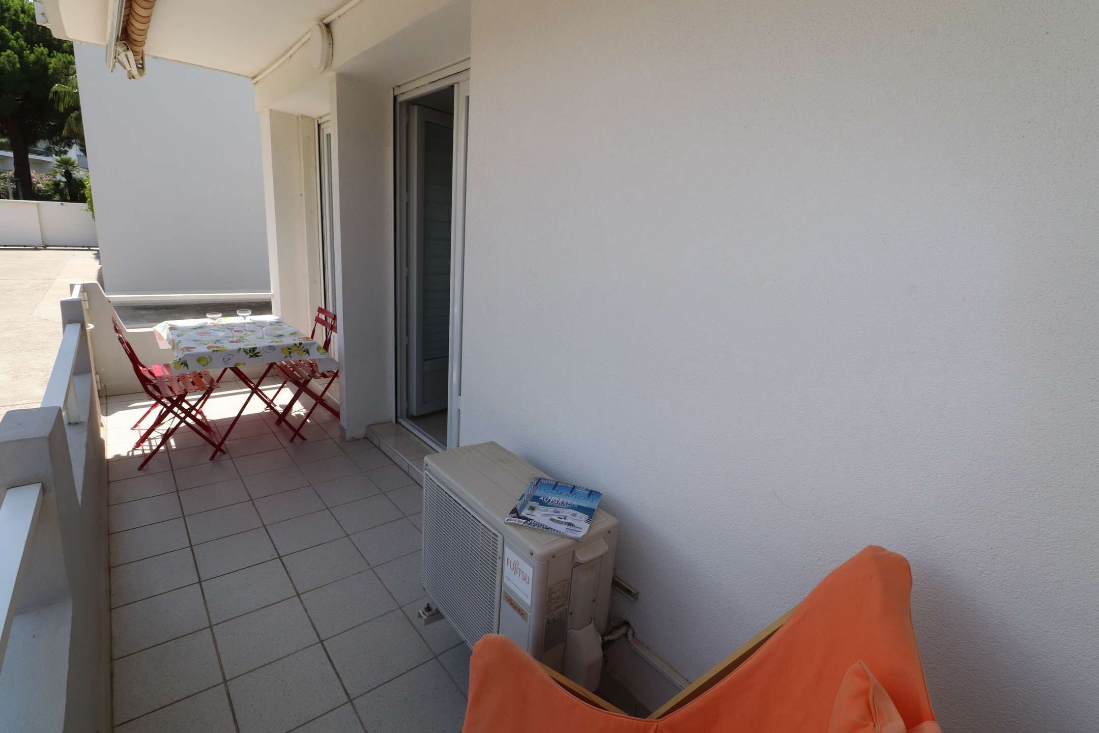 Ein Balkon mit Tisch, Stühlen, einem Fenster und einer Heizung.