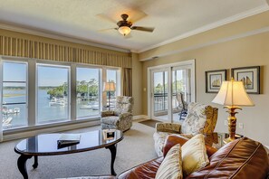 Relax in this stylish living room with a marina view, featuring a comfortable sofa, coffee table, and decorative lamp.